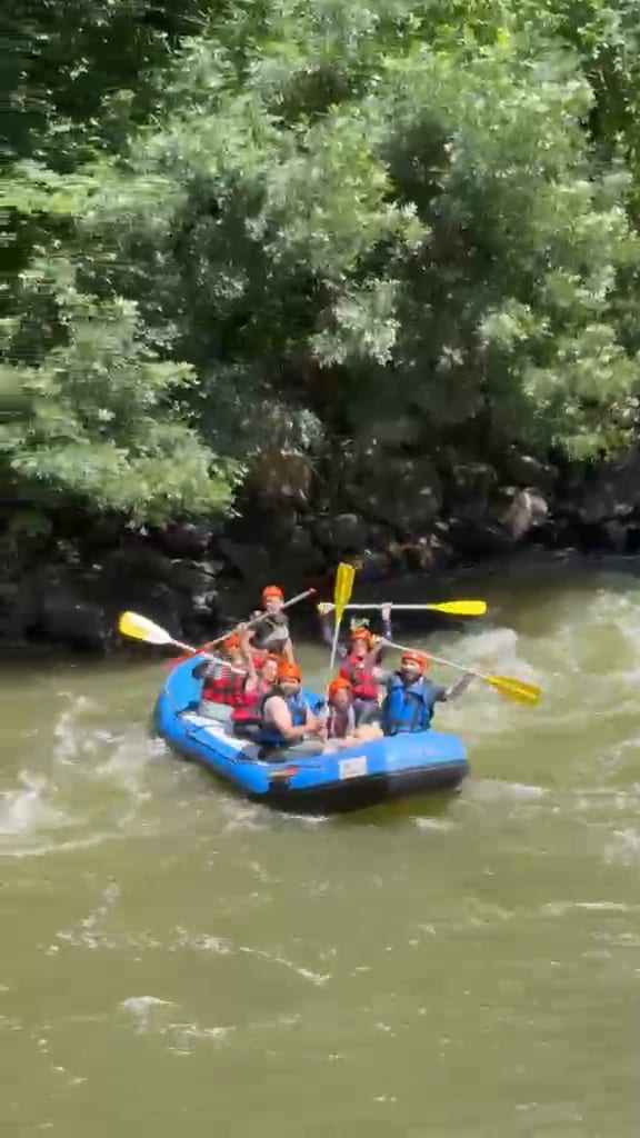 Melen Çayı parkurunda köpüklü akıntıya giren mavi botta uyumlu kürek çeken rafting grubu