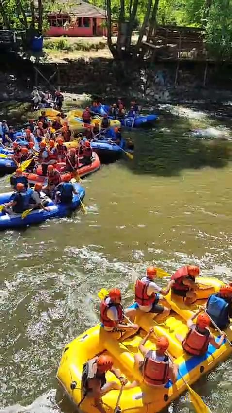 Grup rafting organizasyonunda Melen Çayı akıntısına giren sarı ve mavi botlar ile kürek çeken katılımcılar