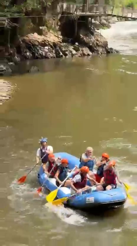 Melen Çayı rafting turunda mavi botta komutla kürek çeken turuncu kasklı katılımcılar