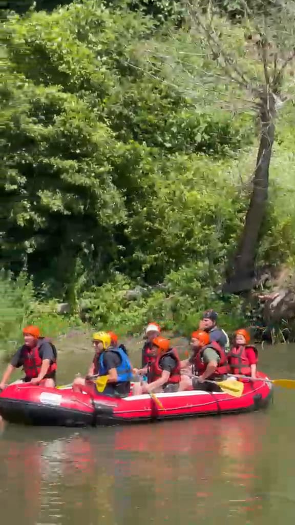 Melen Çayı rafting parkurunda ağaç gölgesindeki kıyıdan suya inen bot ve kask takan grup