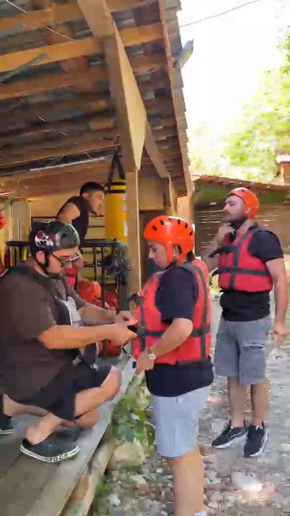 Rafting ekipmanı deposunda katılımcılara can yeleği ve kask dağıtan eğitmenler
