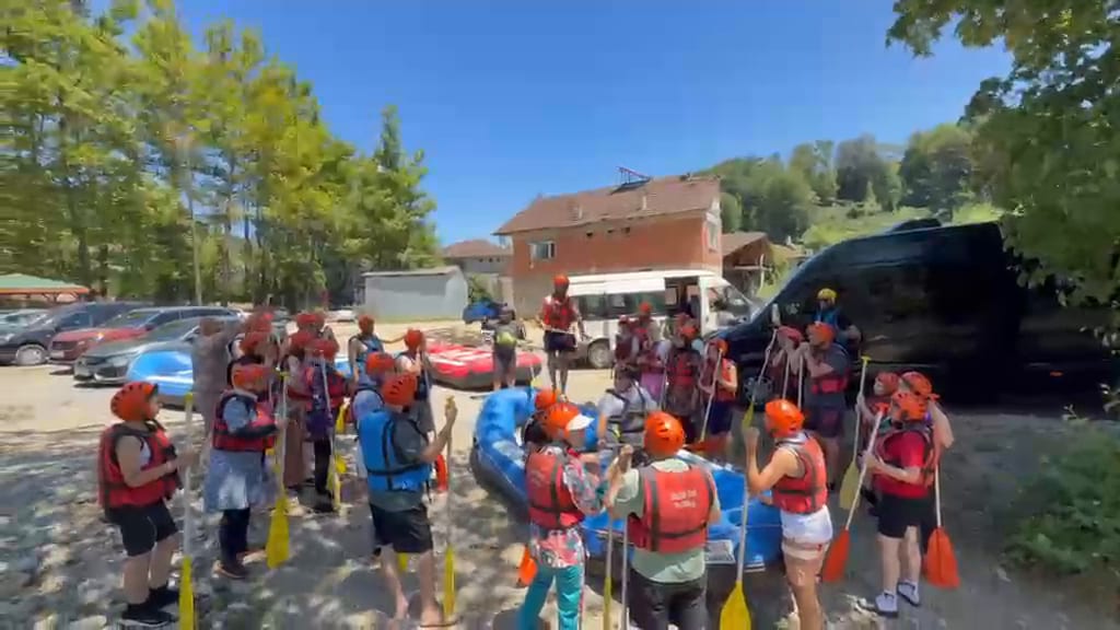 Düzce rafting turunda servis aracının yanında can yeleği ve kask kuşanan kalabalık katılımcı grubu